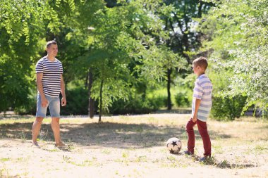 Açık havada futbol oynarken babası olan küçük çocuk