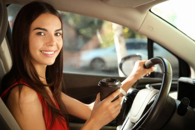 Arabanın sürücü koltuğuna kahve olan kadın