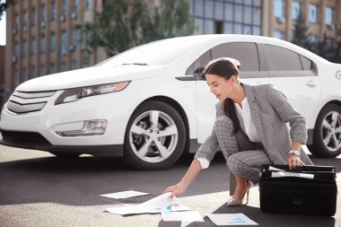 Açık havada acele nedeniyle belgeleri alacak genç iş kadını dağınık