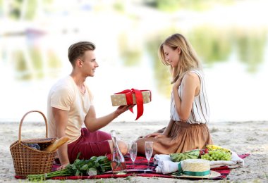 Nehir kenarında romantik tarihte kız arkadaşına hediye veren genç adam