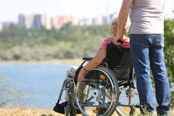 Ανώτερων Γυναίκα Αναπηρικό Αμαξίδιο Και Σύζυγός Της Κοντά Στο Ποτάμι — Φωτογραφία Αρχείου