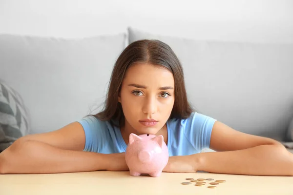 Young woman with piggy bank at home