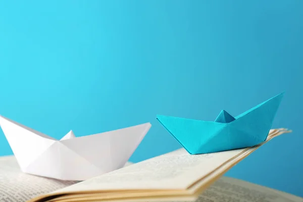 Origami boats on open book, closeup