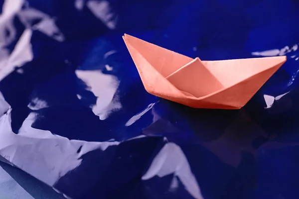 Origami boat on paper imitating waves