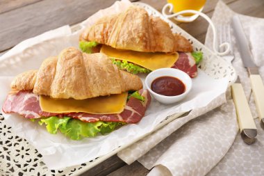 Lezzetli kruvasan sandviç tepsisindeki sosu ile