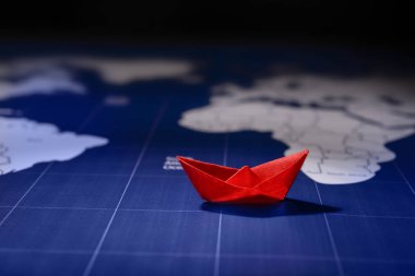 Dünya Haritası üzerinde origami tekne. Seyahat kavramı