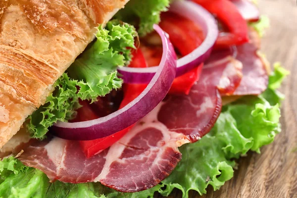 Leckeres Croissant Sandwich Mit Fleisch Und Zwiebeln Auf Dem Tisch — Stockfoto