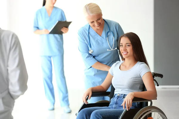 Handicapped young woman with mature female doctor in clinic