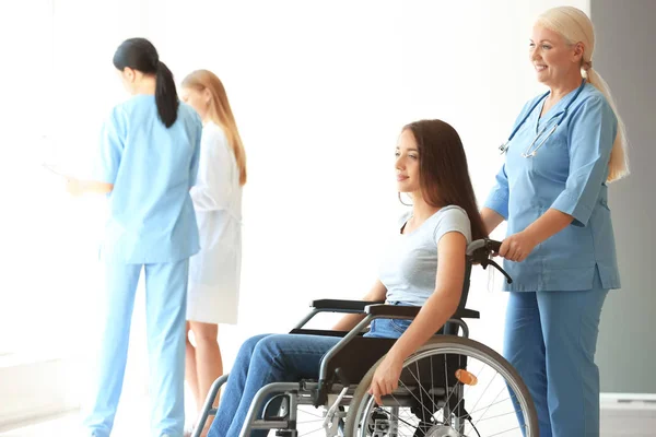 Handicapped young woman with mature female doctor in clinic