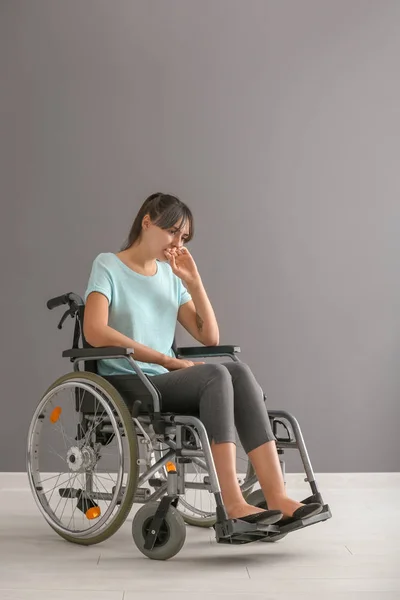 Депрессивная Молодая Женщина Инвалидном Кресле Против Серой Стены — стоковое фото