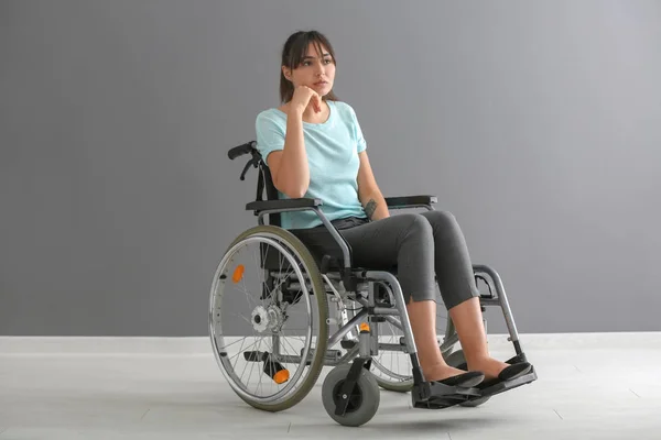 Молодая Женщина Инвалидной Коляске Против Серой Стены — стоковое фото