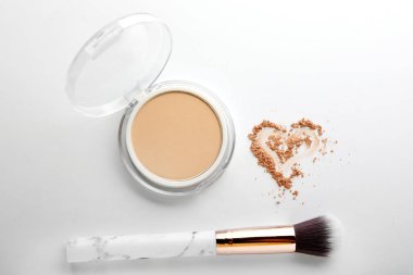 Yüz pudrası fırça ve beyaz zemin üzerine çizilmiş kalp