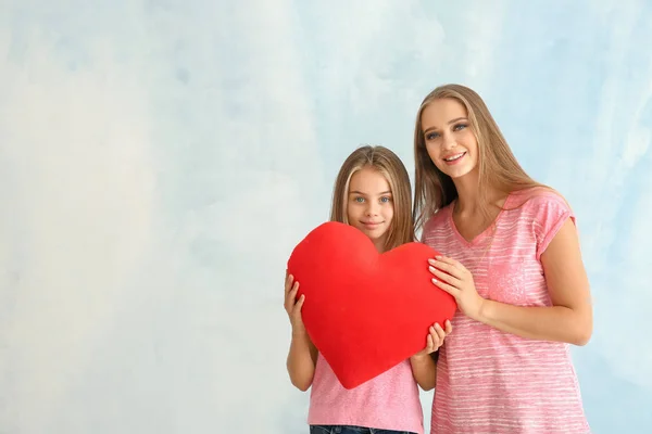 かわいい女の子と彼女の母親が明るい背景にハート型赤 — ストック写真