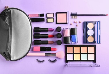 Düz renkli arka plan üzerinde Dekoratif kozmetik kümesi yatıyordu