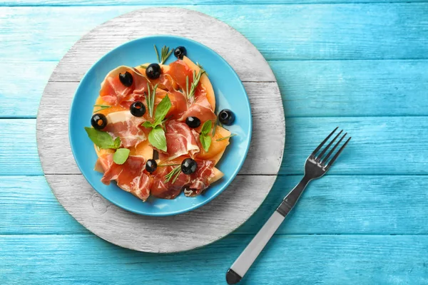 Plaka lezzetli kavun, prosciutto ve zeytin rengi ahşap tablo