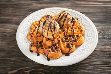 Plaka lezzetli waffle ve ahşap masa dondurma ile