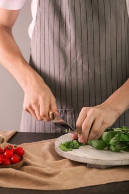 Kadın kesme taze yeşil fesleğen ahşap tahta üzerinde