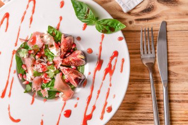 Plaka lezzetli incirli salata ve ahşap masa sosu ile