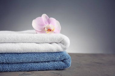 Gri arka plan karşı masada temiz yumuşak havlu yığını