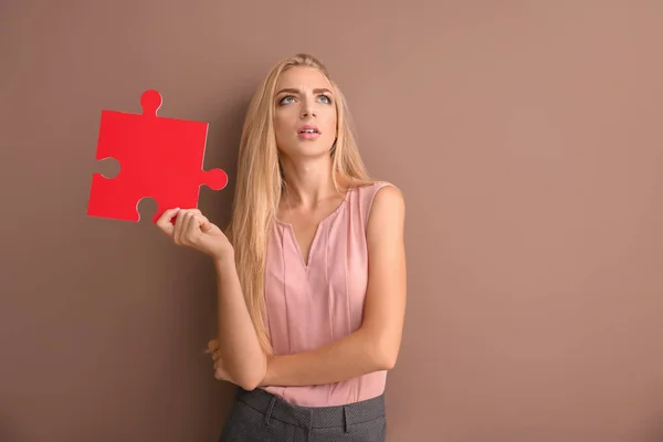 Nachdenkliche Junge Frau Mit Puzzleteil Auf Farbigem Hintergrund — Stockfoto