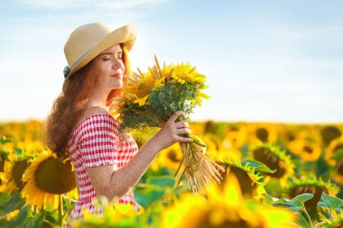 Ayçiçeği alan güneşli güzel kızıl saçlı kadın