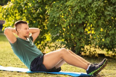 Sportif genç adam dışarıda antrenman yapıyor.