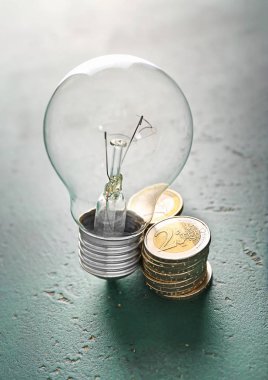 Madeni paralarla ampul renk arka plan üzerinde. Elektrik kavramı kaydetme
