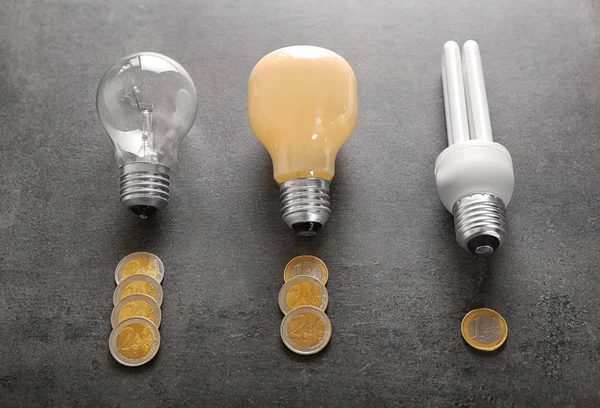 Coins Different Light Bulbs Grey Background Electricity Saving Concept — Stock Photo, Image