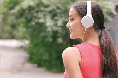 Güzel genç kadın müzik açık havada için dinleme