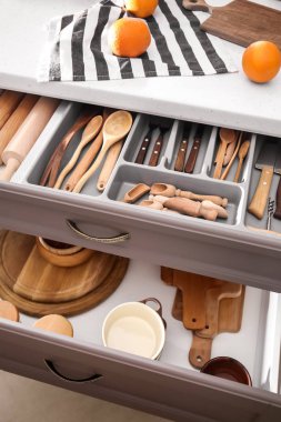 Set of clean kitchenware and utensils in open drawers clipart