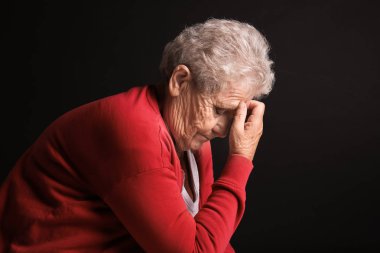 Koyu arka plan üzerinde depresif yaşlı kadın