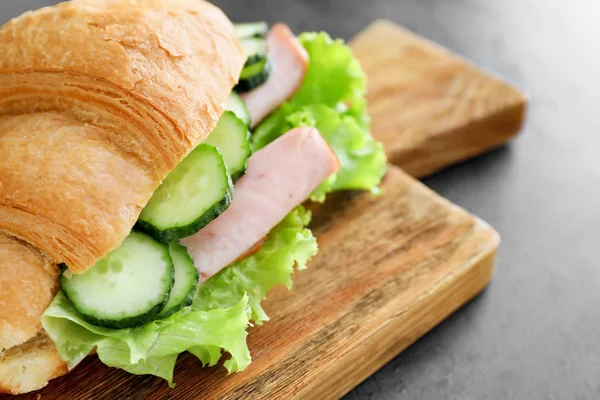 Holzbrett Mit Leckerem Croissant Sandwich Auf Grauem Tisch — Stockfoto