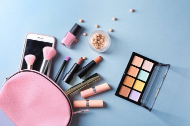 Düz renkli arka plan üzerinde Dekoratif kozmetik kümesi yatıyordu