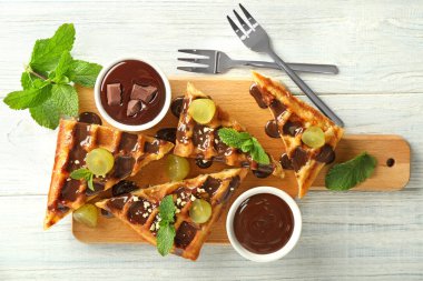 Üzüm ve ahşap tahta üzerinde çikolata sosu ile lezzetli waffle