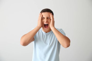 Genç adam ışık arka plan üzerinde vurguladı