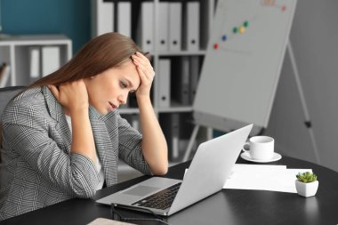 Ofiste baş ağrısı ve boyun ağrısı çeken kadın