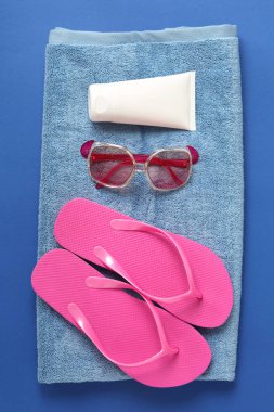 Parmak arası terlik, Güneş kremi ve güneş gözlüğü renk arka plan üzerinde temiz yumuşak havlu