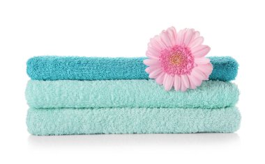 Beyaz arka plan üzerinde çiçek ile temiz yumuşak havlu yığını