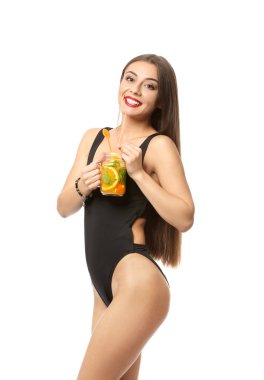 Mason kavanoza lezzetli yaz kokteyl beyaz arka plan üzerinde tutarak yüzme elbiseli güzel kadın