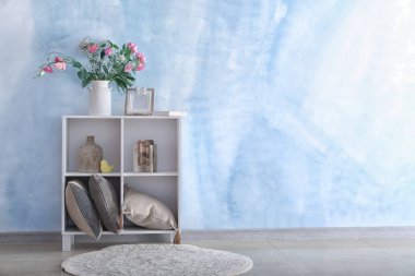 İç dekorasyon ve raf ünitesi yakın renk duvar üzerinde güzel pembe çiçekli vazo