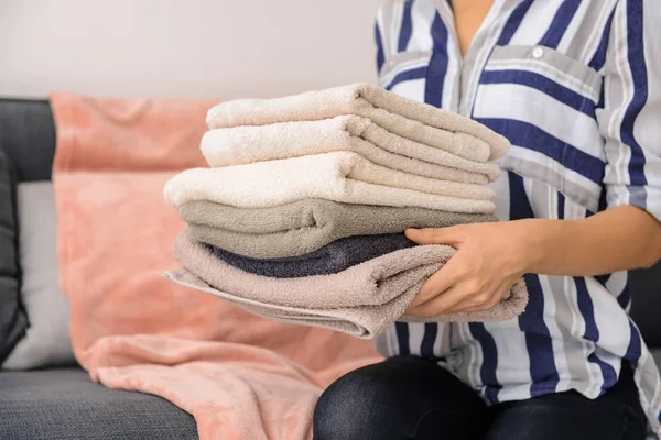 Mulher Segurando Toalhas Limpas Enquanto Sentado Sofá — Fotografia de Stock