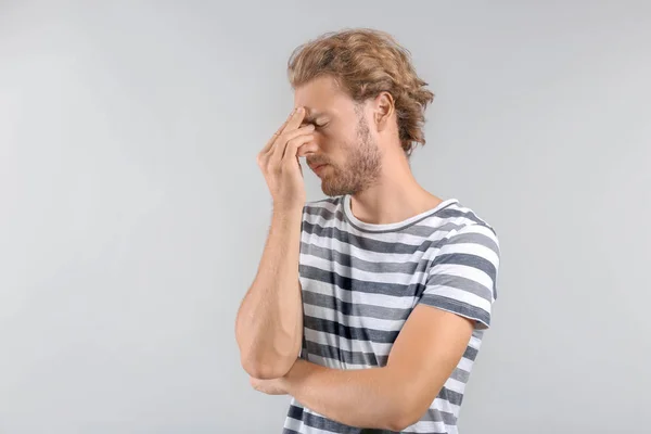 Portrait of stressed man on grey background