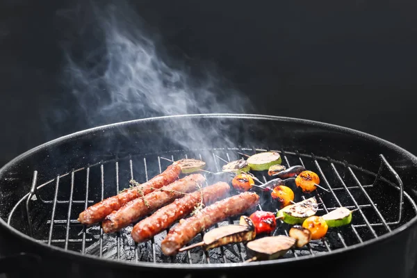 Cuisson Savoureuses Saucisses Légumes Sur Barbecue Sur Fond Sombre — Photo