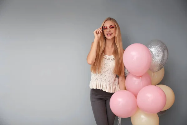 灰色の背景に気球と美しい若い女性 — ストック写真