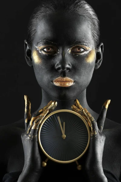 Hermosa Mujer Con Pintura Negra Dorada Cuerpo Sosteniendo Reloj Sobre — Foto de Stock