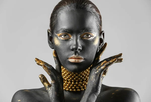 Piękna Kobieta Czarny Złoty Farby Jej Ciele Jasnym Tle — Zdjęcie stockowe