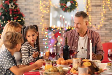 Mutlu bir aile evde Noel yemeği yiyor.