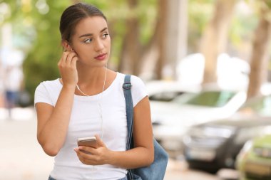 Güzel genç kadın müzik açık havada için dinleme