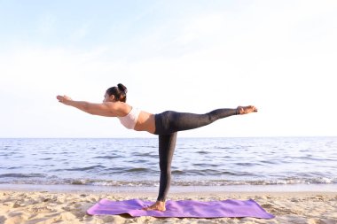 Pratik yoga deniz kıyısında kadın