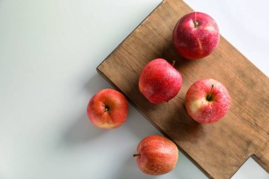 Olgun sulu elma ve ahşap tahta üzerinde beyaz masa